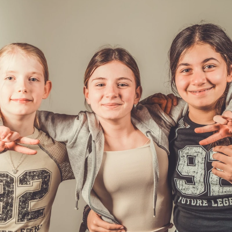 3 mädchen halten sich im arm
